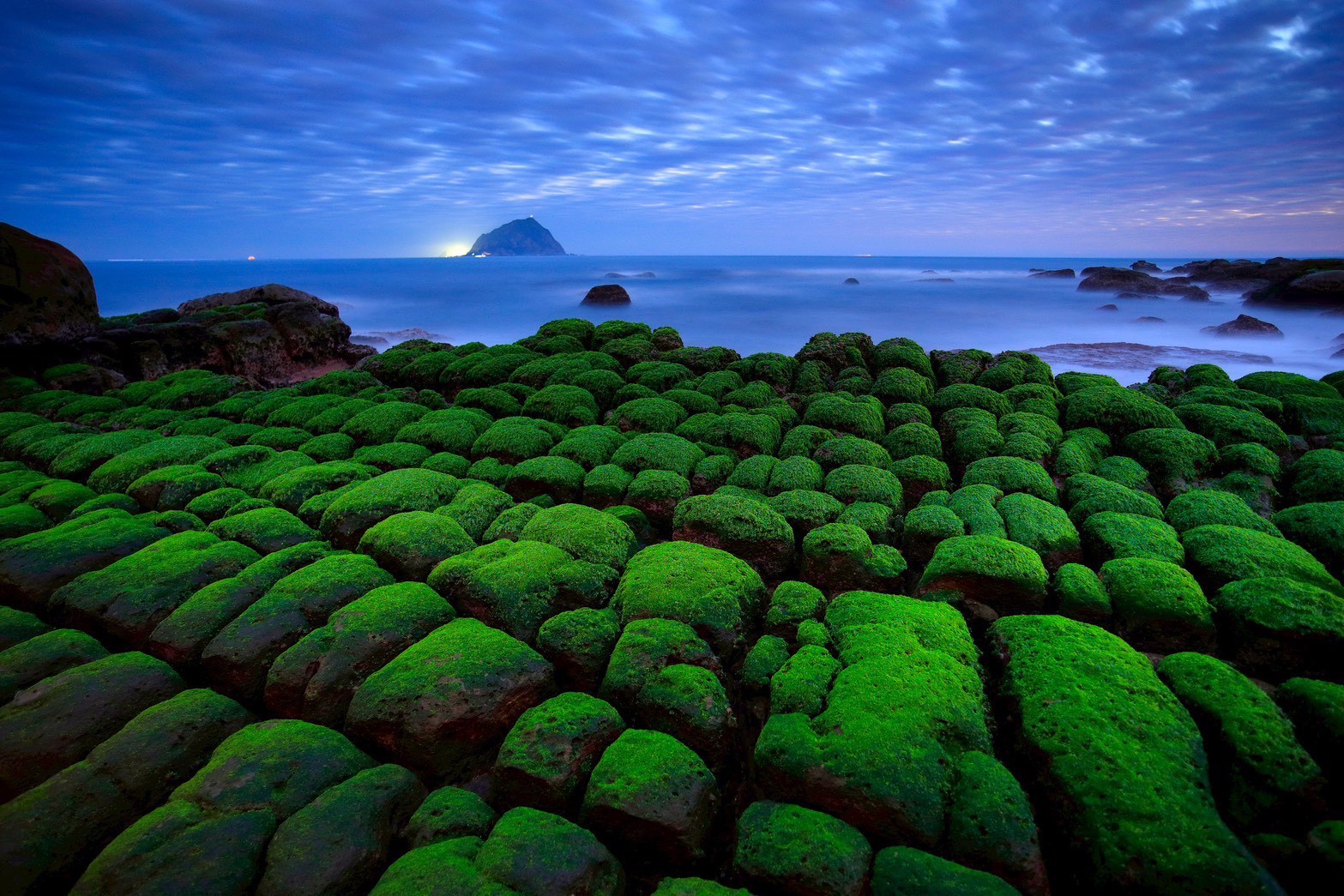 被綠藻覆蓋的岩石，鮮綠與深藍交織成壯麗畫布，吸引無數攝影愛好者追景。圖/北海岸及觀音山國家風景區管理處提供