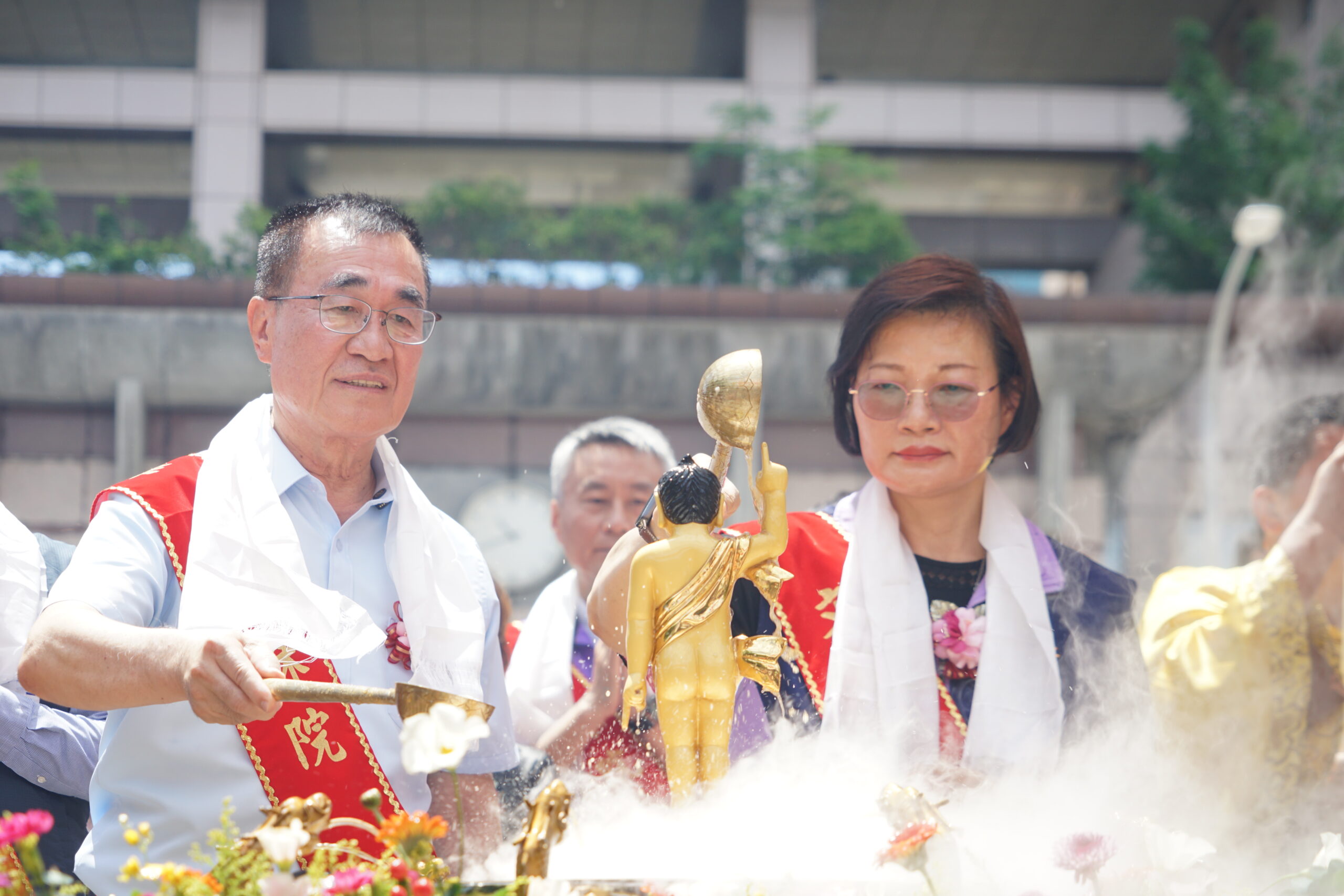 《圖說》世界佛教正心會於板橋站前廣場舉辦浴佛,李四川前副市長及新北市政府社會局李美珍局長浴佛。〈佛教正心會提供〉