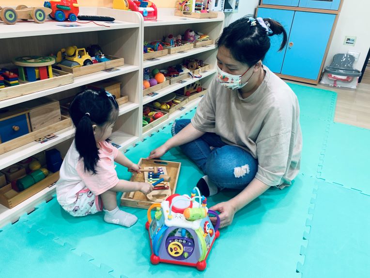 《圖說》中和幸福種子社區定點臨托,托育人員陪伴幼兒敲打樂器。〈社會局提供〉